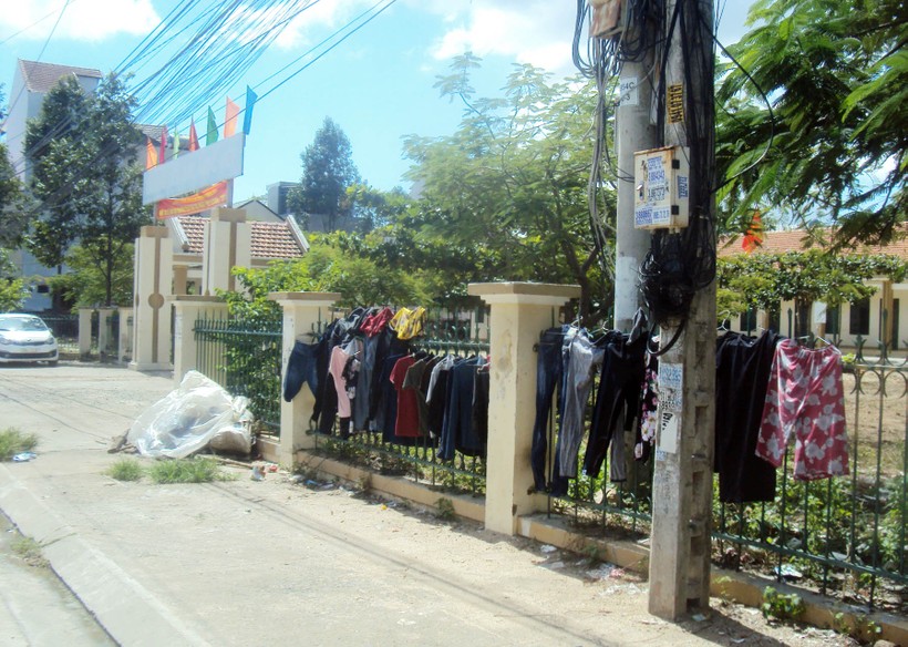 Người dân vô tư phơi quần áo trên hàng rào trường học
