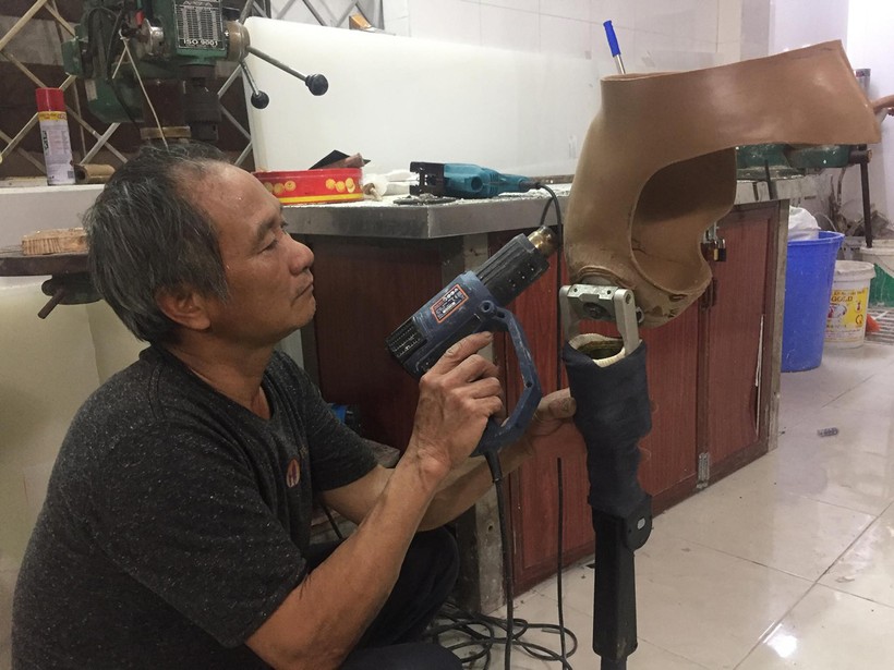 Bác sĩ Lê Thành Đô miệt mài bên xưởng sản xuất chân tay giả, để giúp đỡ những mảnh đời bất hạnh.	Ảnh: Đăng Chung