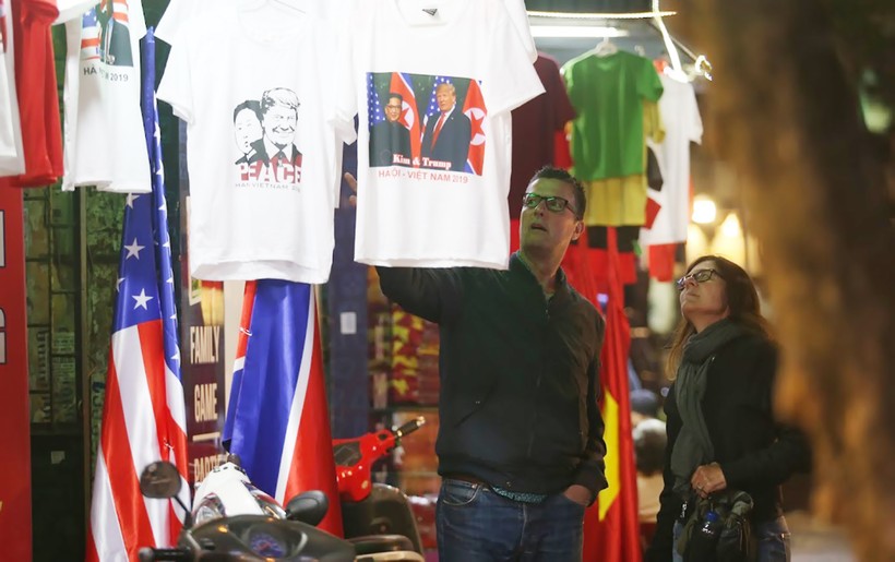 Một cặp du khách nước ngoài đang tìm mua áo có in hình Tổng thống Mỹ và Nhà lãnh đạo Triều Tiên trên phố cổ Hà Nội. Ảnh: Thế Đại