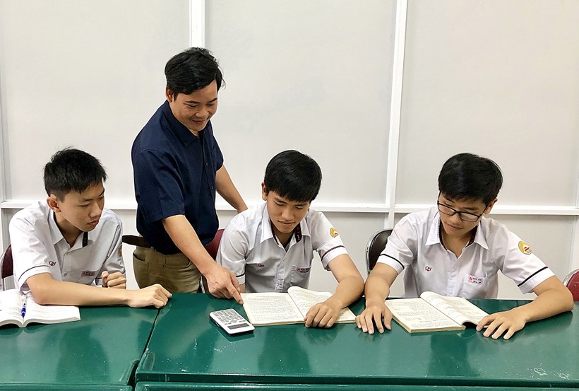 Hoàng Huy Tú (bên phải) cùng thầy giáo và các bạn Trường Quốc học