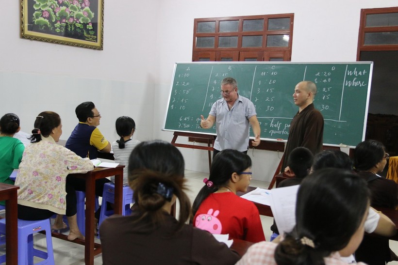 Các học viên trao đổi tiếng Anh với thầy Thom, bên cạnh là tu sĩ Minh Trực. Ảnh: T.G