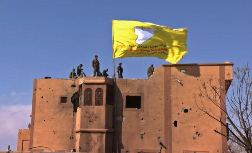 Các chiến binh SDF cắm cờ chiến thắng trên các tòa nhà ở Baghouz.	Ảnh: AFP