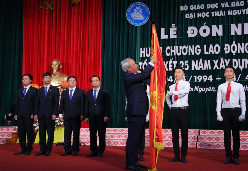 Phó Chủ tịch Quốc hội Uông Chu Lưu gắn Huân chương Lao động hạng Nhất lên lá cờ truyền thống của ĐH Thái Nguyên