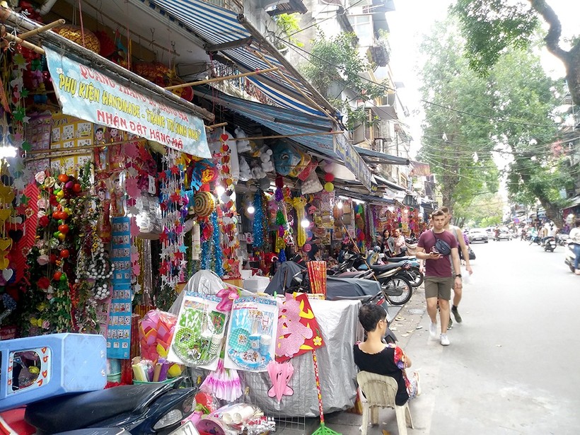 Khách du lịch phải đi xuống lòng đường vì vỉa hè bị chiếm chỗ kinh doanh (Chụp trên phố Hàng Mã, Hà Nội)