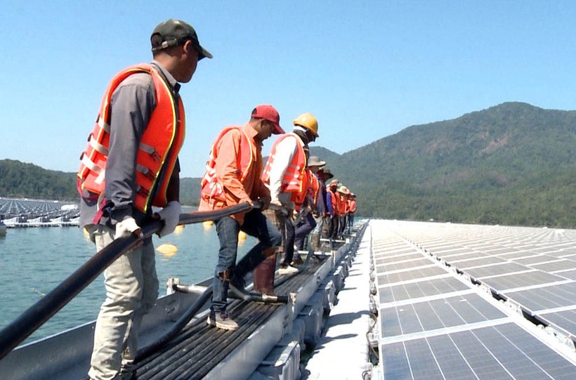 Công nhân kéo dây cáp điện để đấu nối nguồn điện mặt trời vào hệ thống điện tại Dự án Điện mặt trời Đa Mi.	Ảnh: EVN.