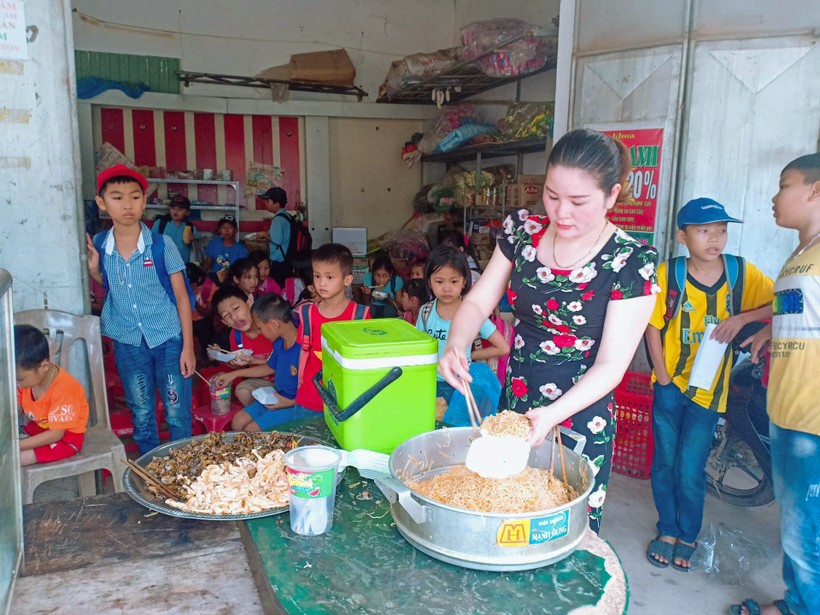 Cô Phạm Thị Thêu chia thức ăn vào hộp cho học sinh