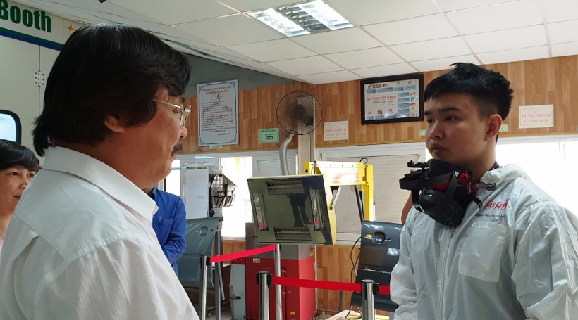 Tổng cục trưởng Tổng cục Giáo dục nghề nghiệp Nguyễn Hồng Minh trao đổi công tác huấn luyện với Nguyễn Xuân Lực, thí sinh nghề công nghệ sơn ô tô.