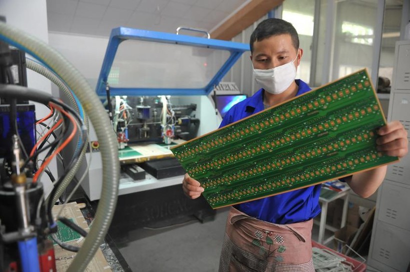 Một nhân viên làm việc trong một cơ sở sản xuất bảng mạch ở Hàng Châu, phía Đông tỉnh Chiết Giang (Trung Quốc).