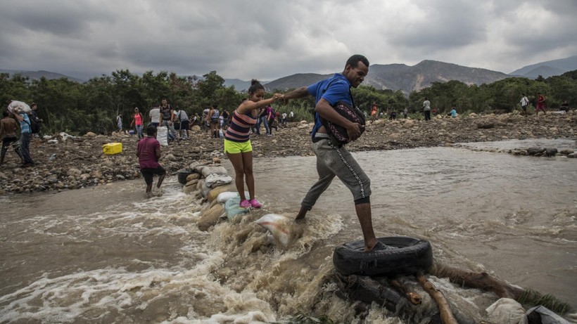 Người di cư Venezuela băng qua sông tới Colombia. Ảnh: UNHCR