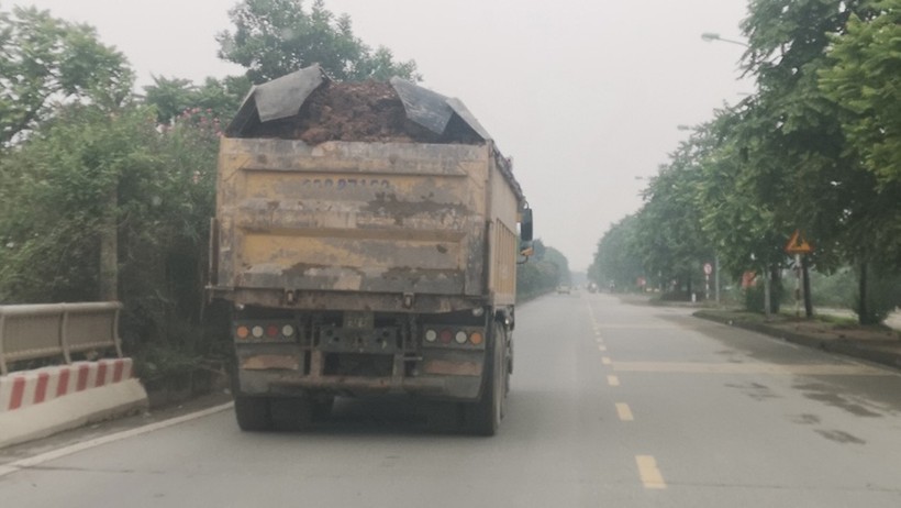 Xe tải chạy trên Đại lộ Thăng Long không được che chắn cẩn thận khiến vật liệu xây dựng
vung vãi ra đường gây bụi bẩn, mất ATGT.