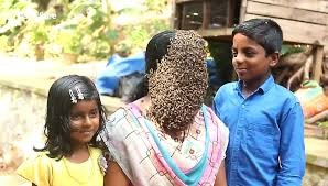 Xem bà mẹ Ấn Độ thản nhiên cho ong bu kín mặt các con