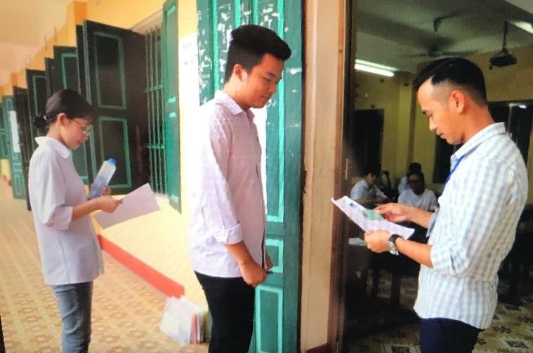 Kiểm tra thẻ dự thi của thí sinh tại điểm thi Trường THPT Nguyễn Huệ.