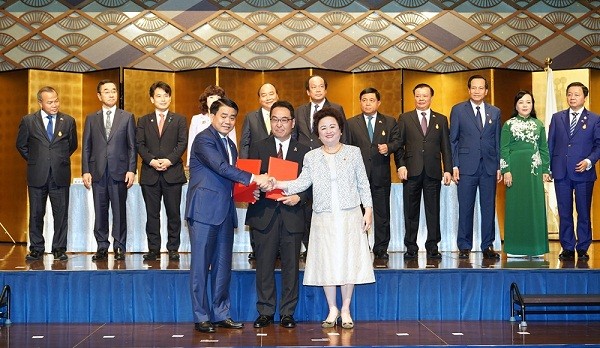 Chủ tịch Thành phố Nguyễn Đức Chung và đại diện các tập đoàn Nhật Bản trao đổi các biên bản ghi nhớ (MOU) về việc hợp tác đầu tư vào nhiều dự án trên địa bàn Thành phố. Ảnh: Thùy Linh.