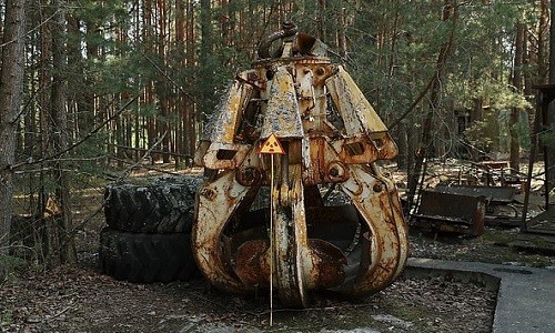 Chiếc móng vuốt máy xúc nhiễm phóng xạ bị bỏ trong rừng. Ảnh: AFP.
