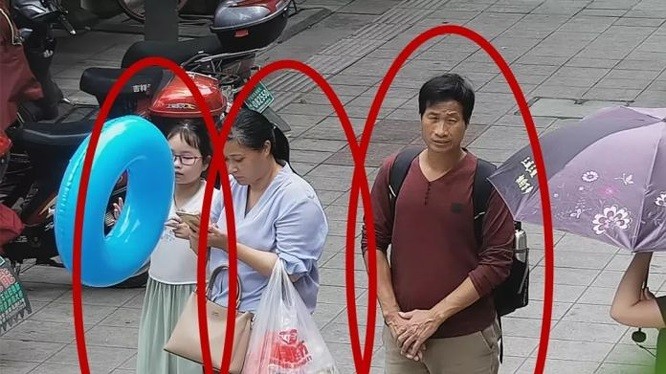 Bức ảnh trích xuất từ camera an ninh cho thấy cô bé Zhang Zixin bị 2 người lớn dẫn đi (Ảnh: Getty).