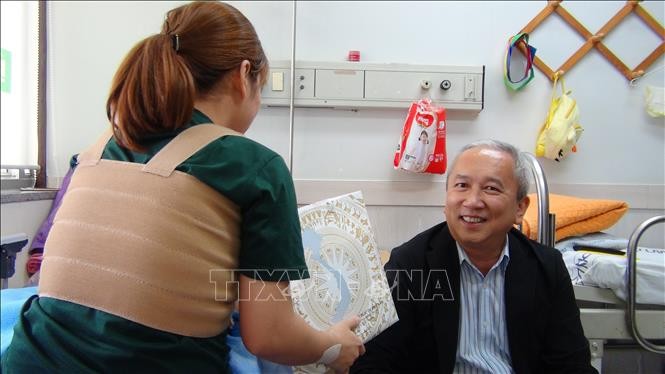 Đại sứ Việt Nam tại Hàn Quốc Nguyễn Vũ Tú (bên phải) tặng quà cho chị L.N.T.G. Ảnh: Hữu Tuyên/TTXVN.