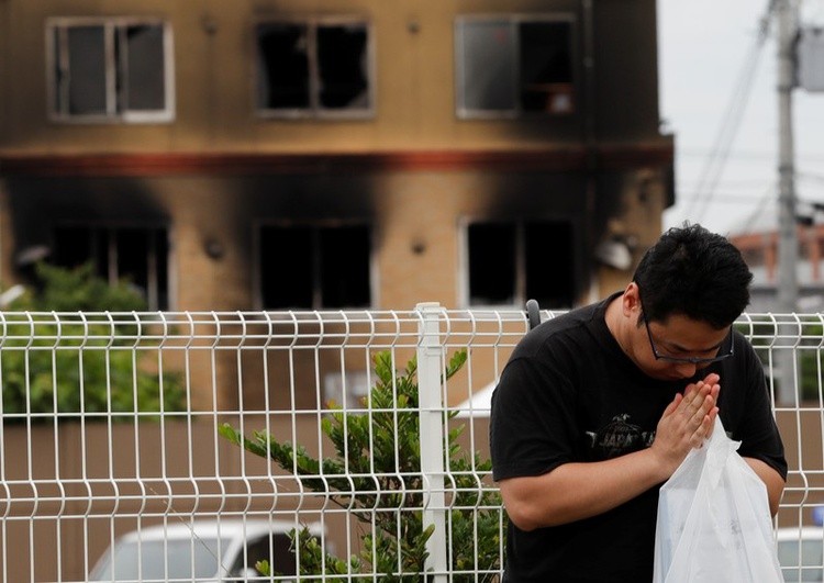 Người đàn ông cầu nguyện cho các nạn nhân trong vụ cháy