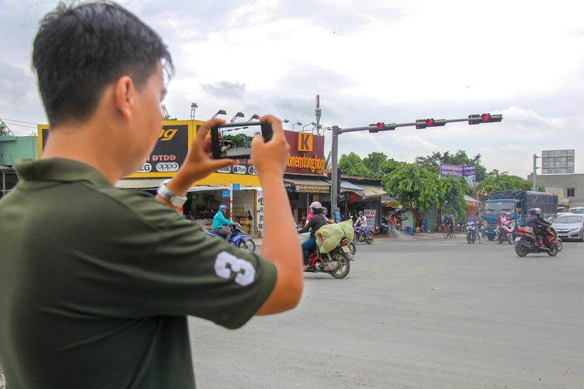 Một thanh niên dùng điện thoại ghi lại hình ảnh vi phạm giao thông tại giao lộ Lê Văn Việt - Hoàng Hữu Nam (Q 9, TP HCM) ngày 6/8. Ảnh: Vĩnh Phú