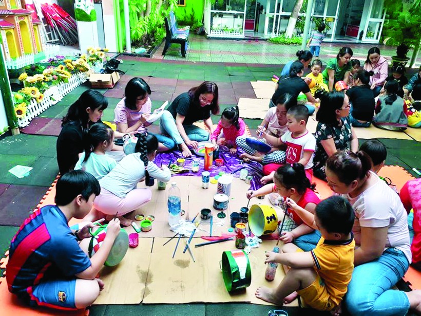 Phụ huynh Trường Mầm non Bình Minh cùng tham gia trang trí các vật dụng tái chế. Ảnh nhà trường cung cấp