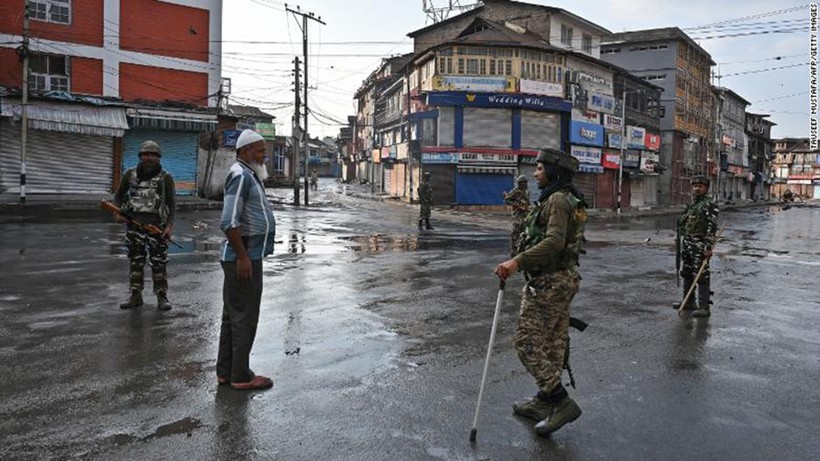 Nhân viên an ninh Ấn Độ thẩm vấn một người đàn ông trên đường phố trong giờ giới nghiêm ở Srinagar ngày 8/8/2019