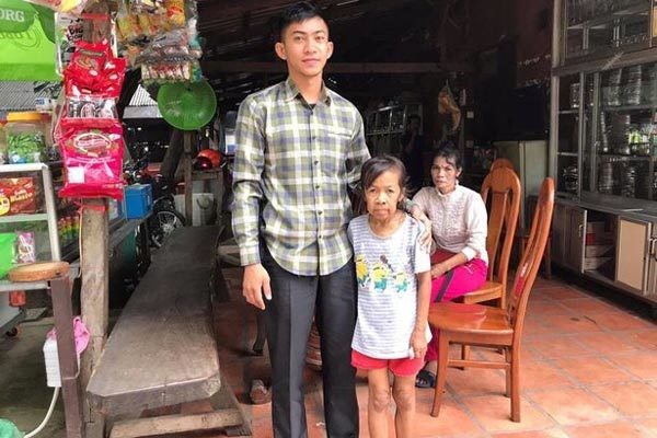 Cô bé Bo, 10 tuổi đứng chụp ảnh lưu niệm với một vị khách tới thăm. Ảnh: Viral Press.