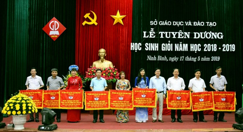 Ông Vũ Văn Kiểm - Giám đốc Sở GD&ĐT Ninh Bình (thứ tư từ phải sang trái) trao tặng cờ thi đua cho các đơn vị có thành tích xuất sắc