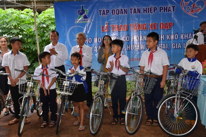 Đại diện Tập đoàn Tân Hiệp Phát và chính quyền địa phương trao tặng xe đạp cho các em học sinh nghèo hiếu học.