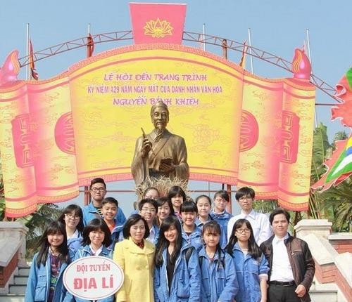 Thầy giáo Ngô Huy Thành (ngoài cùng bên phải) cùng cô giáo Lê Thúy Hạnh (Hiệu trưởng Trường THCS Trần Phú) chụp ảnh lưu niệm với học trò khi dâng hương đến Trạng trình Nguyễn Bỉnh Khiêm.