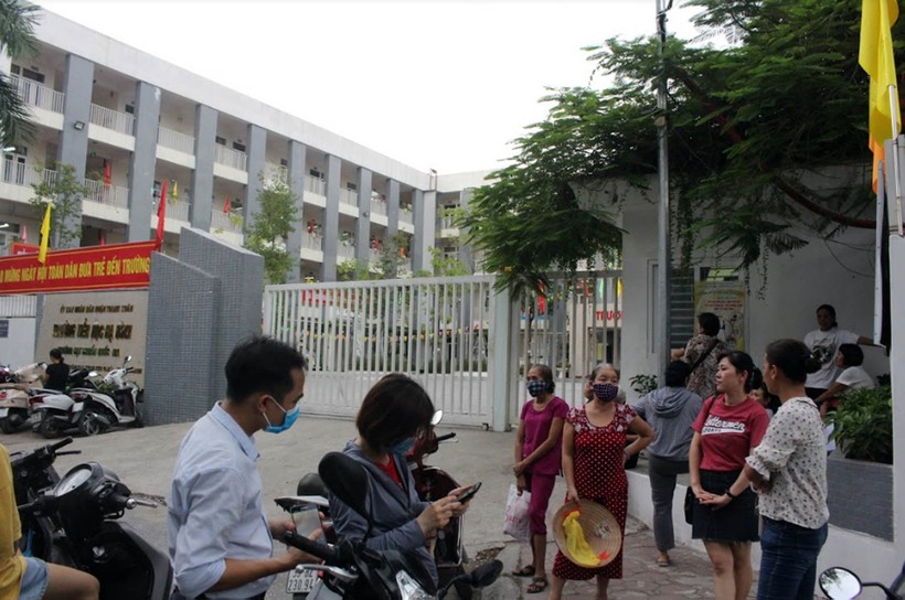 Nhiều phụ huynh lo lắng, đeo khẩu trang khi đón con tại khu vực cổng Trường Tiểu học Hạ Đình