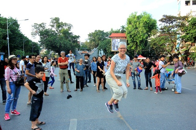 Khách du lịch thích thú với một trò chơi trên phố đi bộ ở Hà Nội. 

