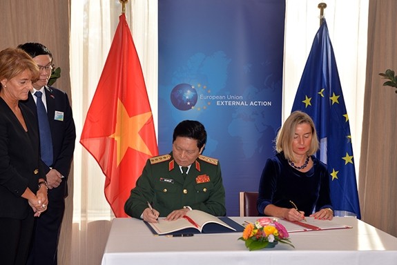 Đại tướng Ngô Xuân Lịch  cùng bà Federica Mogherini ký Hiệp định FPA. Ảnh: Quân đội nhân dân