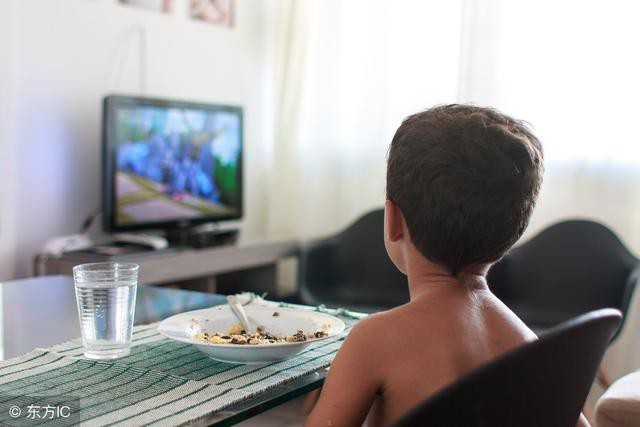 Rất nhiều trẻ có thói quen vừa ăn vừa xem ti vi (Ảnh minh họa).