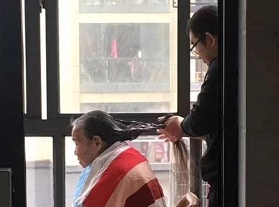 Hình ảnh anh Xu chăm sóc tóc cho mẹ hiện được chia sẻ nhiều trên mạng xã hội ở Trung Quốc. Ảnh: China News.