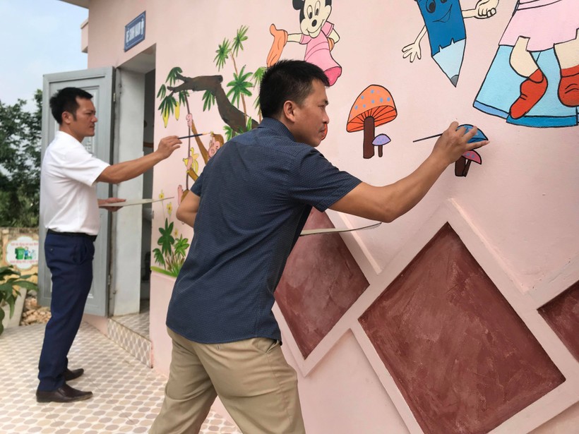Các thầy giáo Mỹ thuật trường Tiểu học Tất Thắng (huyện Thanh Sơn) trang trí nhà vệ sinh trong trường học.