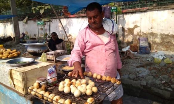 Một người bán hàng rong ở Patna đang nướng bánh litti chokha. Ảnh: The Guardian.