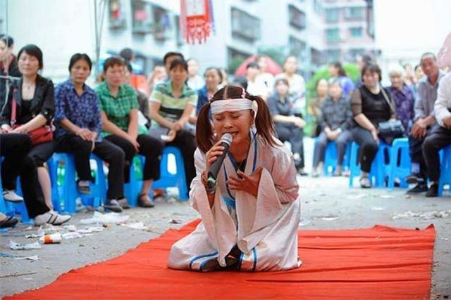 Một phụ nữ khóc thuê chuyên nghiệp tại đám tang ở vùng nông thôn Trung Quốc. Ảnh: NPR.