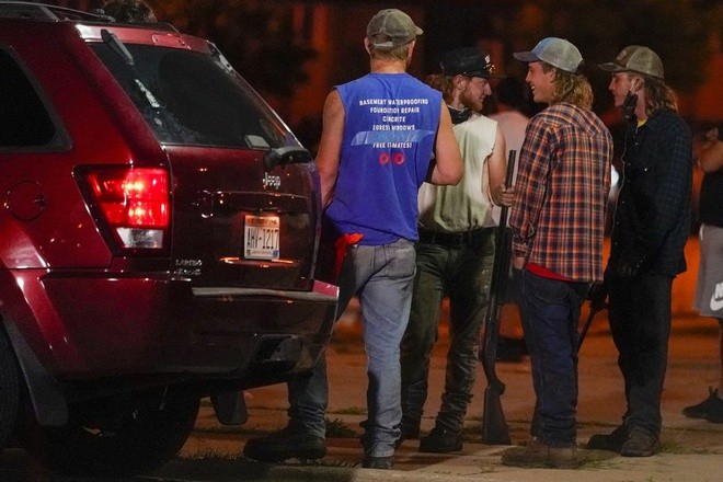 Một nhóm người cầm súng trường quan sát người biểu tình trên đường phố Kenosha, bang Wisconsin, hôm 25/8. Ảnh: AP.