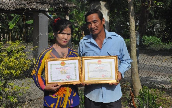 Vợ chồng ông Bùi Văn Vẽ nhận giấy khen của Xã Phương Phú vì đã hiến đất xây trường học