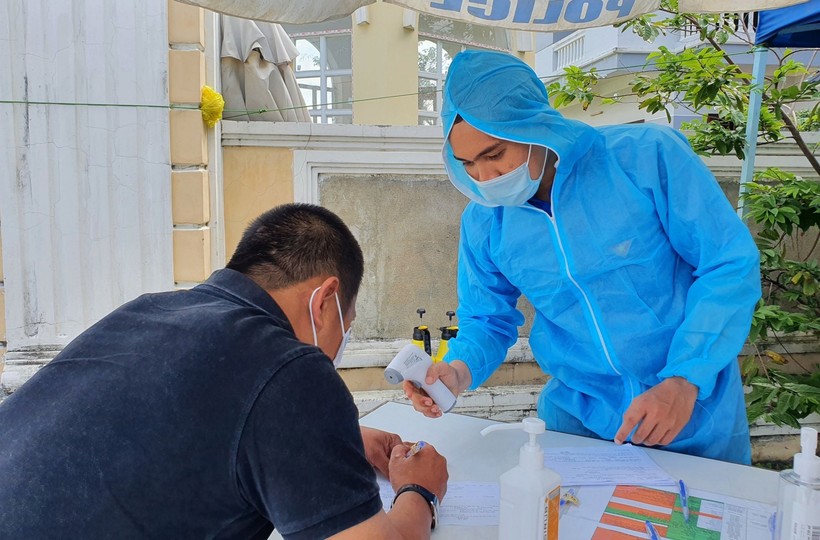 Anh Nguyễn Cao Sang đang hỗ trợ người dân khai báo y tế trước khi vào thành phố.