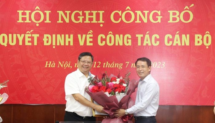Phó Chủ tịch UBND thành phố Hà Nội Nguyễn Trọng Đông trao quyết định, tặng hoa chúc mừng ông Nguyễn Anh Quân.