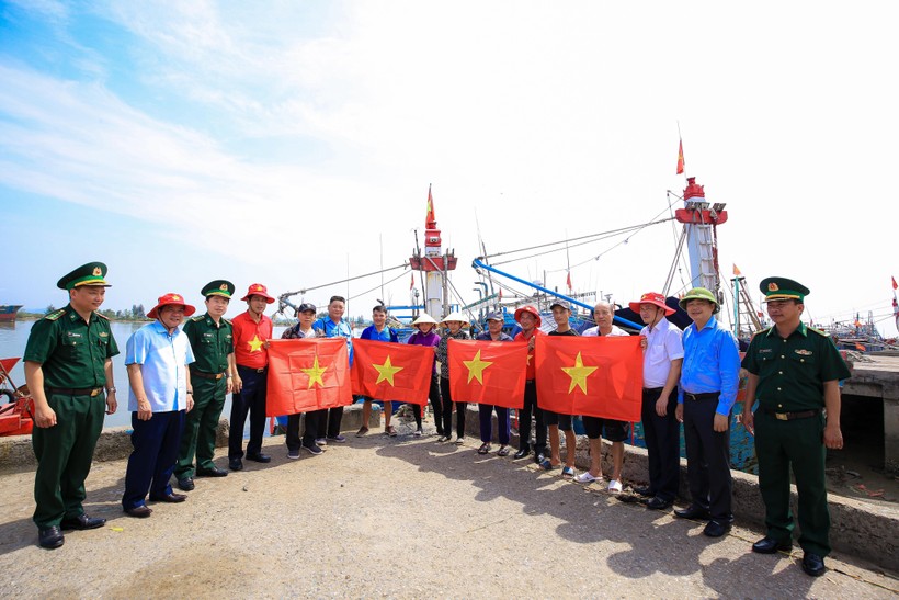Báo Người lao động phối hợp với các Ban, ngành trao cờ Tổ quốc đến ngư dân bám biển. (Ảnh: TM).