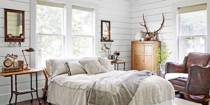 Phòng ngủ sơn màu trắng, nhưng đã thêm một loạt các vật phẩm mang gam trung tính, giường ngủ, chăn cổ và ghế da cũ để sưởi ấm căn phòng. 