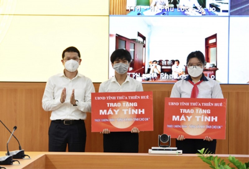 Ông Hoàng Hải Minh - Phó Chủ tịch UBND tỉnh Thừa Thiên Huế trao tượng trưng máy tính tặng cho 2 em học sinh mồ côi cha mẹ do Covid-19. (Ảnh tư liệu)