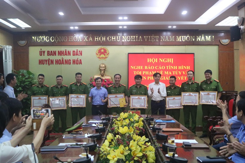 Ông Lê Thanh Hải - Chủ tịch UBND huyện Hoằng Hóa (áo xanh) trao giấy khen, phần thưởng cho 8 cá nhân có thành tích xuất sắc trong công tác phòng, chống tội phạm về ma túy.
