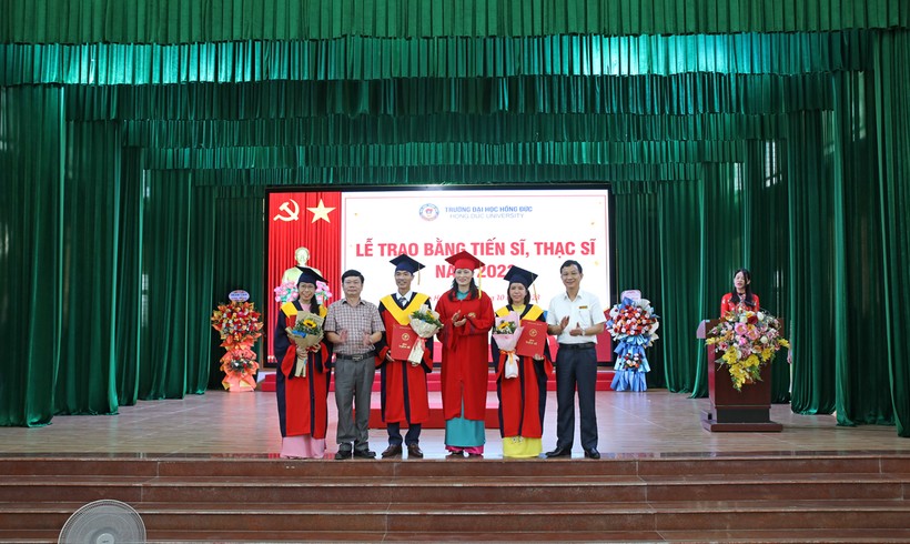 Đại diện ban lãnh đạo nhà trường trao bằng tốt nghiệp cho các tân tiến sĩ. 
