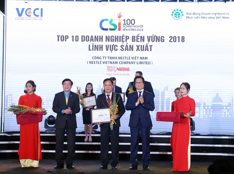 Ông Vũ Tiến Lộc, Chủ tịch VCCI Vũ Tiến Lộc, trao Bằng khen và hoa cho đại diện Nestlé Việt Nam
