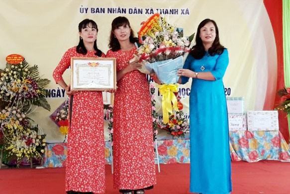 Phó Giám đốc Sở GD&ĐT - Nguyễn Thị Thu Huyền  trao Giấy khen của Giám đốc Sở GD&ĐT và tặng hoa cho nhà trường.